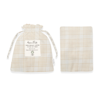 A beige plaid flannel cot sheet displayed next to its matching drawstring bag packaging.