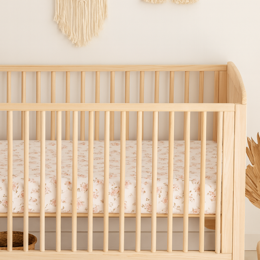 Nursery room with a wooden crib, macrame wall hanging, and decorative arch.