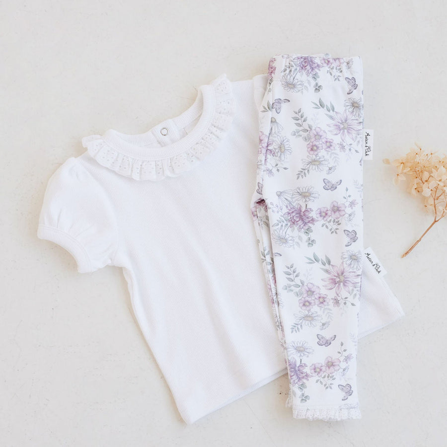 White top and floral pants on a light background